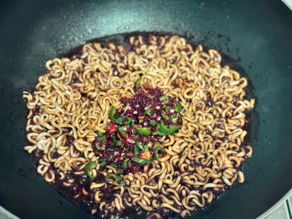 Chapagetti noodles with spicy chili topping added before mixing.